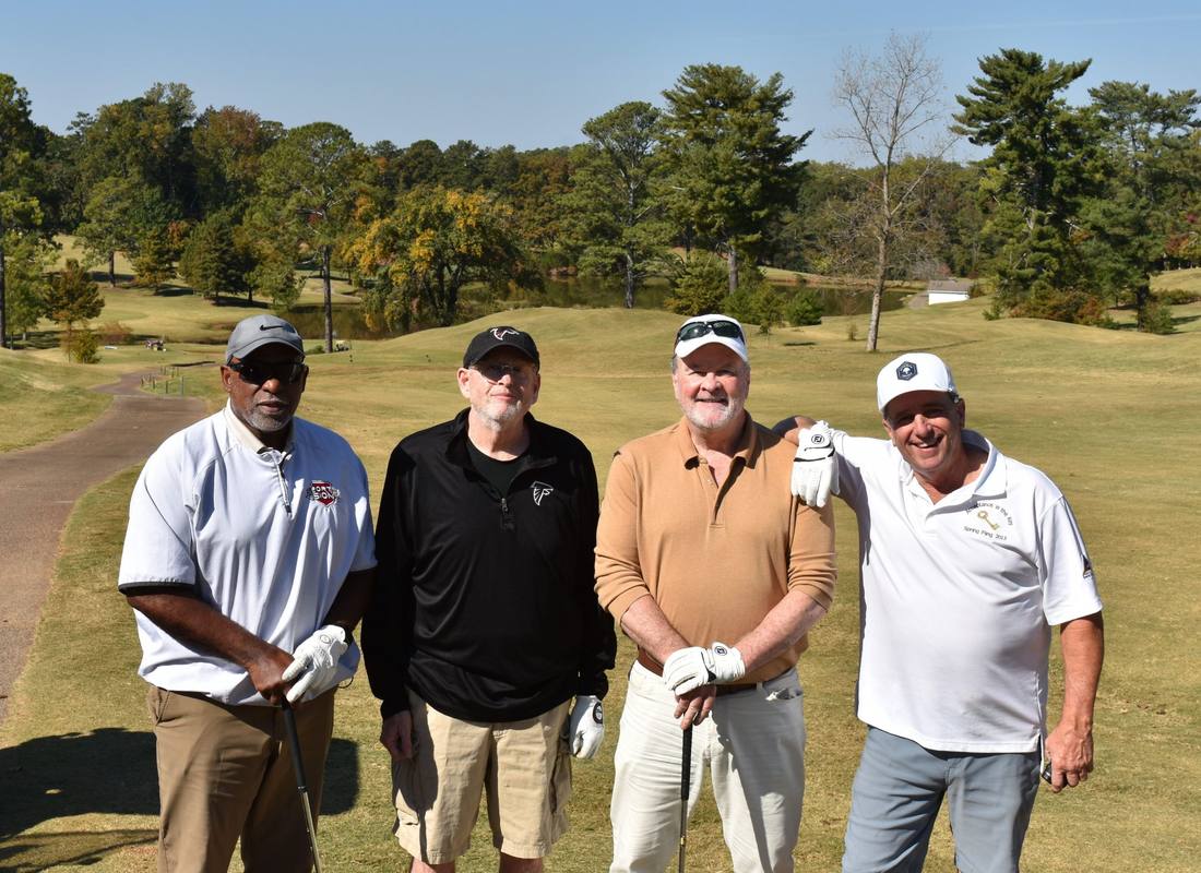 A foursome smiling on the course at the Sam Anders Serenity Scramble